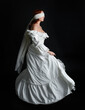 © faestock - close up portrait beautiful female model wearing antique white historical ghost bride wedding dress gown, a veiled mask blindfold covering face. isolated figure on dark studio background, hand gesture