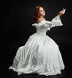 © faestock - Full length portrait beautiful female model wearing antique white historical ghost bride wedding dress gown. classical elegant sitting pose, Isolated figure on dark studio background