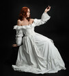 © faestock - Full length portrait beautiful female model wearing antique white historical ghost bride wedding dress gown. classical elegant sitting pose, Isolated figure on dark studio background