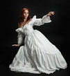 © faestock - Full length portrait beautiful female model wearing antique white historical ghost bride wedding dress gown. classical elegant sitting pose, Isolated figure on dark studio background