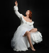 © faestock - Full length portrait beautiful female model with red hair wearing a antique white historical ghost bride wedding dress gown. classical elegant sitting pose, Isolated figure on dark studio background