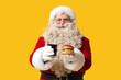 © Pixel-Shot - Santa Claus with tasty burger and soda on yellow background