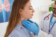 © Pixel-Shot - Male endocrinologist examining woman's thyroid gland in clinic, closeup