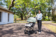 © leungchopan - Mother pushing baby stroller at sunny park