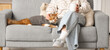 © Pixel-Shot - Woman with coffee and cute cat relaxing on sofa at home