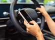 © Barillo_Images - Close-up of smartphone in hand of woman behind steering wheel