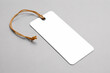 © STDIO BLACKHOLE - Blank white rectangular cardboard tag with brown string on gray background ready for design mockup or product labeling