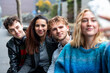 © Westend61 - Group of friends taking a selfie outdoors in an urban setting