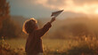 © IrinZatsepina - Child launching a paper plane at sunset in a field