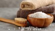 © Taisiia - A wooden bowl filled with sea salt for spa treatments, accompanied by a folded towel, a brush, and a delicate orchid branch for a relaxing, luxurious atmosphere