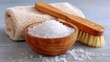 © Taisiia - A wooden bowl filled with sea salt for spa treatments, accompanied by a folded towel, a brush, and a delicate orchid branch for a relaxing, luxurious atmosphere
