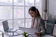 © Wasana - Businesswoman working with documents and laptop in modern office
