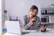 © Wasana - Businesswoman working from home office using digital tablet and talking on phone