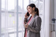 © Wasana - Businesswoman talking on phone and taking notes in office