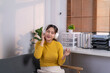© Wasana - Asian freelancer woman enjoying music in headphones at home office