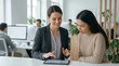 © Unknown OP - A senior financial advisor mentoring a junior colleague, using a digital tablet to explain market data in a busy office