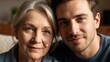 © Mr - Elderly woman and young adult man posing together with heads together in a cozy indoor setting with soft lighting and a blurred background