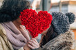 © tetxu - A couple kisses in the street, holding a heart-shaped bouquet. Valentine's Day vibes filled with love and gifts.