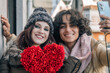 © tetxu - A happy Caucasian couple takes a selfie holding a paper heart. Valentine's Day celebration.