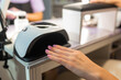 © руслан малыш - Close up of female hand curing gel nail polish under UV LED lamp in beauty salon. Professional manicure process, nail drying, cosmetic treatment, hygiene and nail care concept.