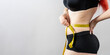 © Alfonso Soler - Woman measuring waist with tape for weight loss