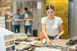© JackF - Young woman buyer choosing soft carpet samples in building store