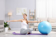 © New Africa - Pregnant woman exercising with fitness ball at home