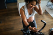 © Davor - Woman working out on exercise bike at home