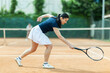 © JackF - Adult female tennis player making serve during game on tennis court