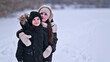 © shine.graphics - Two happy children in winter coats embracing in a snowy landscape