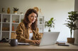 © Miljan Živković - Woman working on laptop achieving remote work goals