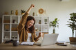 © Miljan Živković - Woman freelancer celebrating business success working from home office