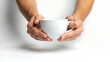 © Zobia - Hands holding a plain white ceramic coffee mug or tea cup against a white background, morning coffee ritual, simple minimalist concept, hot beverage, ceramic drinkware, handle detail, cozy lifestyle,