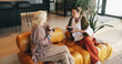 © Azeemud25/peopleimages.com - Friends, women and conversation with coffee on couch, storytelling and weekend visit for connection. Above, gossip session and mature people with tea in home for reunion, discussion and recall memory