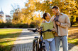 © BGStock72 - Couple enjoys a sunny autumn day while biking in a beautiful park filled with fall colors
