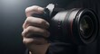 © Nur Uddin - Professional photographer holding camera lens in hand with dramatic lighting