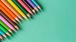 © savittree - Colorful assortment of sharpened pencils neatly arranged on a vibrant turquoise background for art and creativity themes
