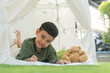 © Kunlathida - Happy Asian little child in garden tent outdoor in nature for camping