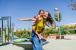 © Koldo_Studio - Young mother giving her happy daughter a piggyback ride on a sunny day in an urban playground, enjoying family fun