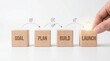 © Happy - Wooden Blocks Depicting Business Development Stages: Goal Plan Build Launch.