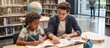 © ON - Studio - Young male tutor helping a young girl with schoolwork in a library. Diverse student and teacher studying together with a textbook. Education and mentorship concept
