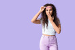 © Pixel-Shot - Beautiful surprised African-American woman with sunglasses on lilac background