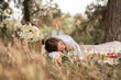 © svetograph - Picnic Daisies Woman: Girl relaxes in grass near basket of daisies blanket on a picnic outdoors during daytime.