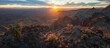 © Travel 'n' Lifestyle - View of the sun's radiant fingers stretch across a rugged, desert landscape dotted with spiky cacti and rocky outcrops at sunset, Nipton, California, United States.
