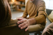 © AnnaStills - Middle aged man comforting middle aged Caucasian woman by placing hand on her shoulder, both sitting indoors, showing support and empathy during conversation