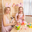 © Tatyana Gladskih - Happy woman and her Child dressed in pink clothes are getting ready for Easter, looking at camera