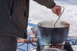 © T.Den_Team - Outdoor winter cooking, man preparing food in cauldron