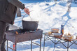 © T.Den_Team - Outdoor winter cooking, man preparing food in cauldron