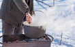 © T.Den_Team - Outdoor winter cooking, man preparing food in cauldron
