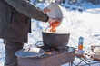 © T.Den_Team - Outdoor winter cooking, man preparing food in cauldron